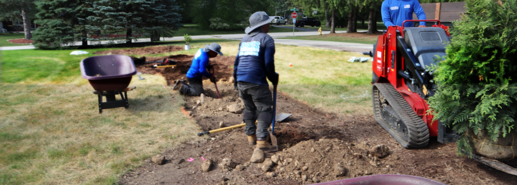 Oasis Lawncare crew working on a mid-summer landscape bed renovation in Waukesha County