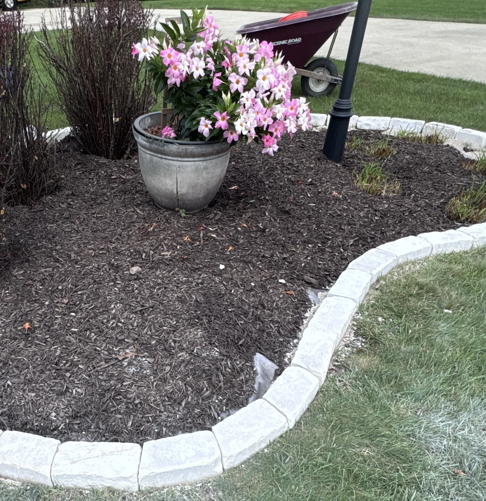 Detail of stone border fitting along a curved planting bed during installation